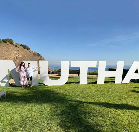 Hope Dworaczyk Smith and Cassandra Grey in Front of a Large MUTHA™ Logo