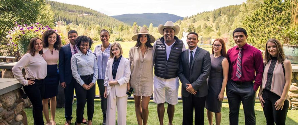 Hope Dworaczyk Smith and Robert F. Smith wear hats and stand outside in Colorado with young members of Together We Rise
