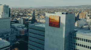 A drone or helicopter view over the top of tall buildings in a major city