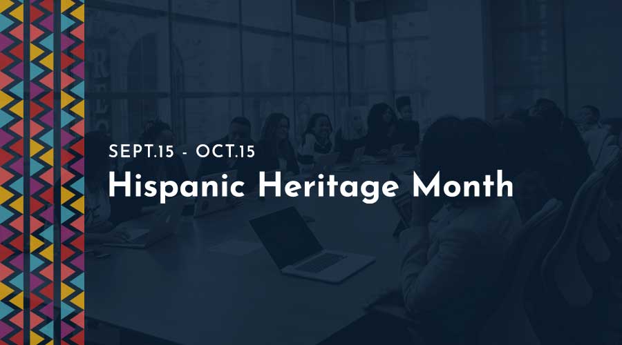 A group of business professionals sit at a corporate table with an overlay colorful graphic to the left of this post with Hispanic Heritage Month text in the middle.