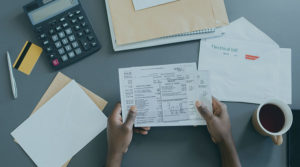 A photo of bills piled up on a desk.