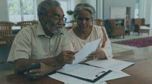 An image of an elderly couple sitting down and going over papers together.