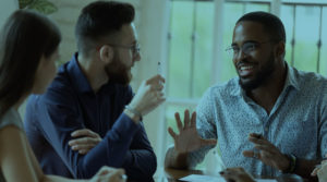 Image of three people sitting down and speaking to one another