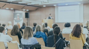 Image of an audience sitting and watching a presentation