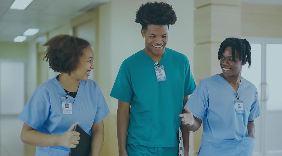 An image of three Black nurses in scrubs while smiling