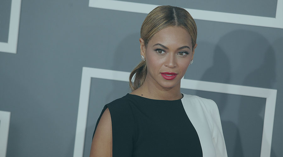 Beyoncé in a white and black dress with earings and red lipstick at 2013 Grammy Awards