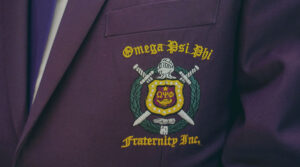 Image of a purple sports coat with the Omega Psi Phi Fraternity, Inc. coat of arms stitched on the front