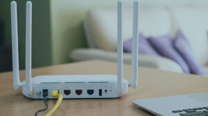 A white router with wires plugged into it placed on top of a wood countertop