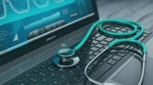 Laptop with a teal stethoscope on top of the keyboard