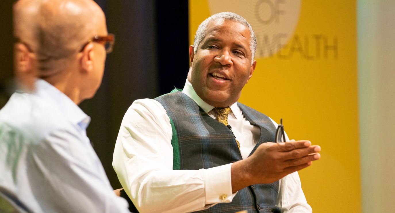 Robert F. Smith actively speaks to another business individual at an event