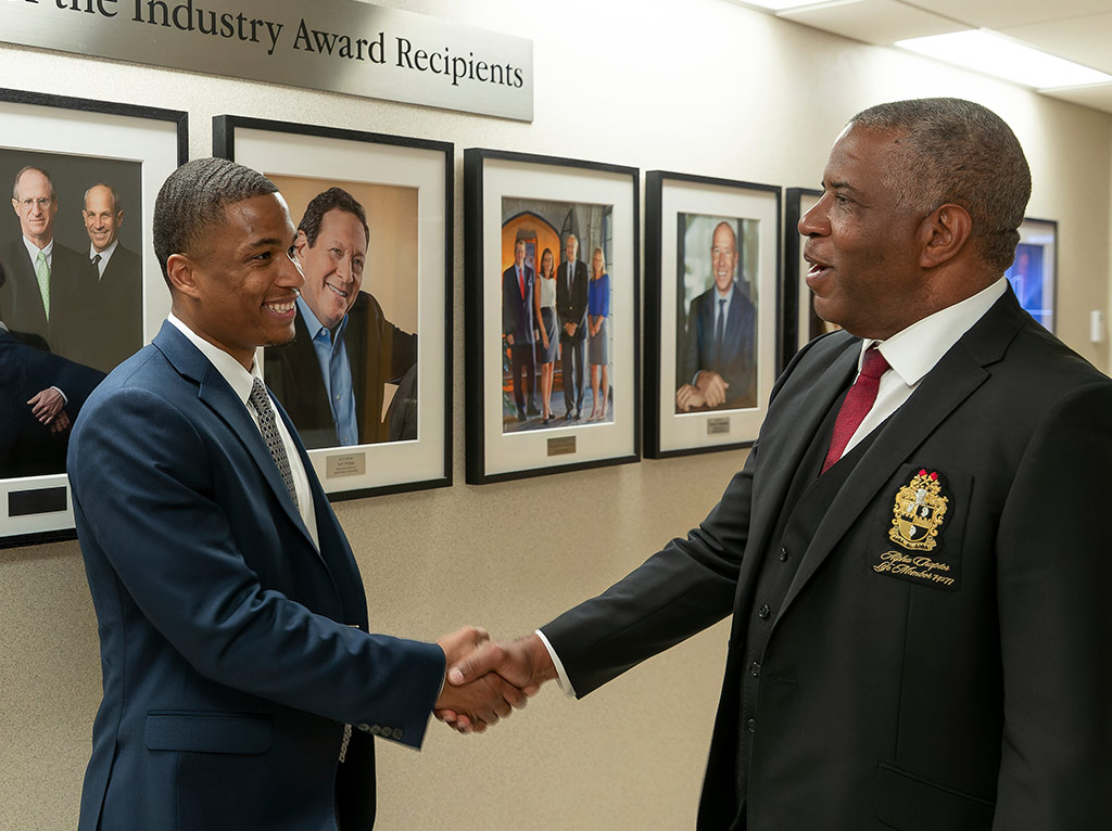 Robert F. Smith shaking hands with another man at Cornell University after receiving an award