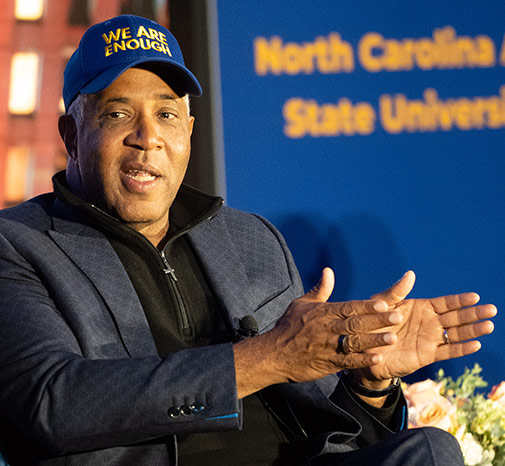 Robert F. Smith visits North Carolina State A&T University and wears a blue hat and suit