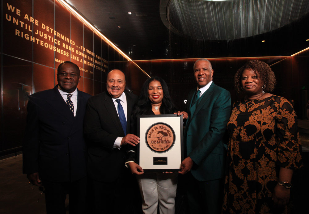 Reverend Dr. W. Franklyn Richardson, Martin Luther King III, Arndrea Waters King, Robert F. Smith, and Michelle Commander stand together, holding a commemorative plaque