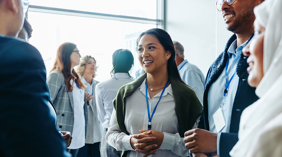 A group of professionals in conversation at a networking event.