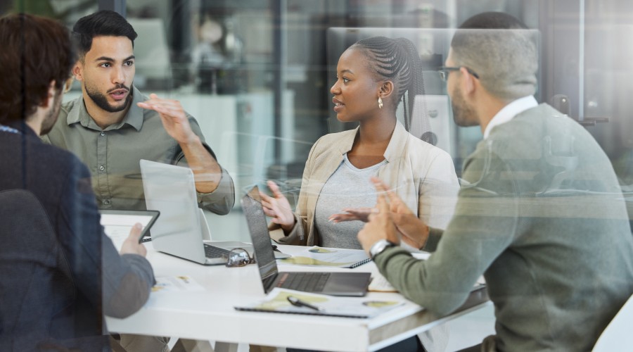Colleagues discussing ideas around a conference table in a modern office.